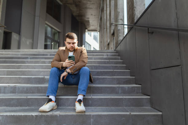 istock Breaktime Connectivity: Confident Manager on Office Building Stairs with Smartphone 2148716560
