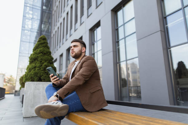 istock The man using smartphone sitting on the bench near the office 2148716895