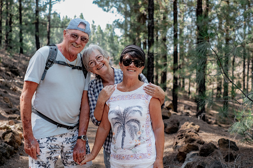 Carefree group of senior people walking in mountain footpath in Tenerife enjoying healthy lifestyle and freedom in nature. Elderly retired and adventure ageless concept.