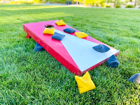 Corn hole board game with bean bags on lawn in summer for fun leisure activity