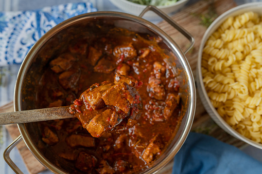 Fresh cooked goulash or ragout hungarian style on a wooden spoon Table top view