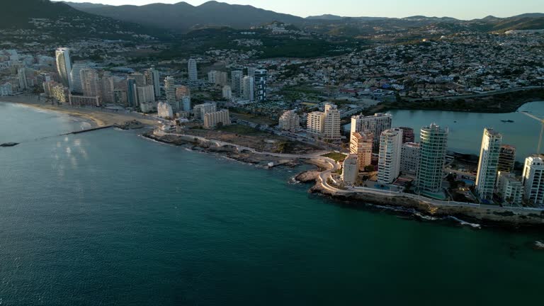 Cinematic aerial view of Calpe city at sunset. Coastline with skyscrapers.
