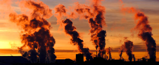 istock Factory Pumping Pollution Into Air Smokestack Environment Emissions at Sunset 2148717966
