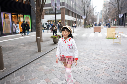 Little girl walking without wheelchair / crutches on cit street. She usually uses wheelchair but could walk with crutches or even without crutches for a short time.