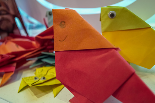 Close-up of paper folding in bird shape. Kids' diy, artcraft. Creative work.