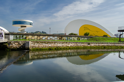 Centro Cultural Internacional Niemeyer, junto ría, Aviles. Torre moderna. Reflejos en el agua de la ría. Aviles, Asturias, España. Septembrer 10, 2023.