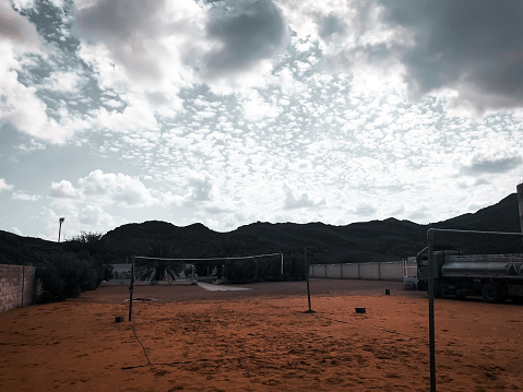 Estadio de voleibol en Farm en la ciudad de Hail, Arabia Saudita, y detrás del estadio de la montaña y las nubes photo