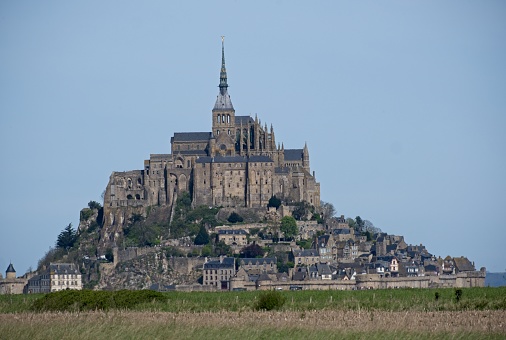 Mont-Saint Michel,France,March 11 2023: Tourists walking around Mont-Saint Michel on a rainy day. Mont-Saint Michel is one of the most popular attractions in France to international tourists.