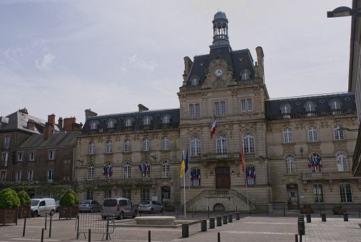 Coutances, France - Apr 14, 2024: City hall. People walking in Coutances. Streets and buildings. Lifestyle in the urban area. Sunny spring day. Selective focus