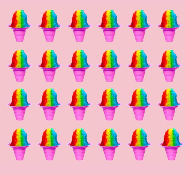 Repetitive Rainbow Hawaiian Shave Ice, Shaved Ice or Snow Cone desserts arranged on a pink as a background