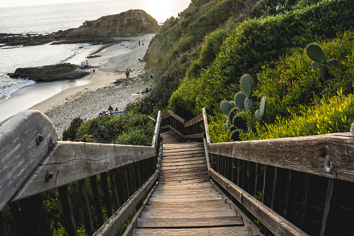 Laguna Beach, California, United States - February 17th  2024: A wooden staircase leads up to a beach.