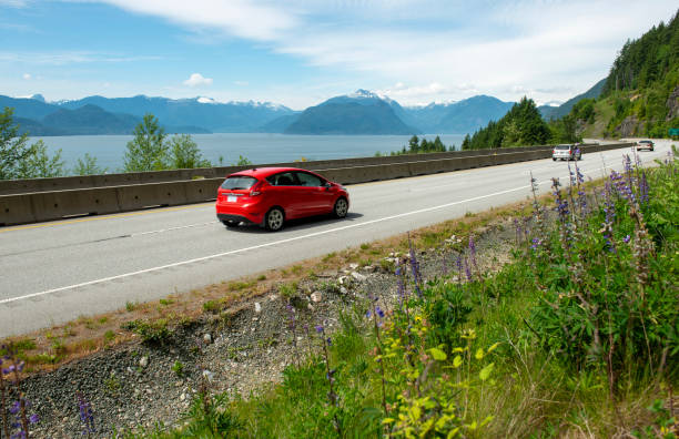 Vehicles on mountain highway Vehicles drive down sea to sky mountain highway, Pacific Ocean nearby pacific northwest region stock pictures, royalty-free photos & images