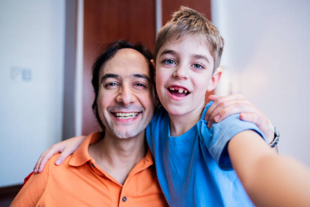istock Father and son taking a selfie at home - camera point of view 2148725117