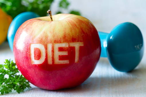 Red apple with cut-out word diet and dumbbell, diet and healthy lifestyle concept idea