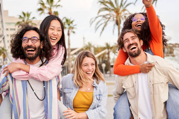 istock Interracial group of friends having fun, doing piggybacks outdoors during trip to a tropical country 2148725840