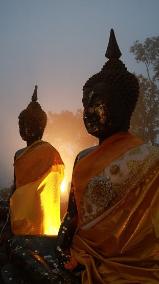 The three Buddha statues during sunset sitting on top of the mountain in Khao Khitchakut National Park located in Chanthaburi of Thailand