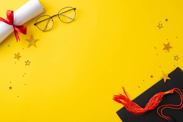 istock Milestone setting. Overhead perspective displaying graduation cap, rolled diploma, ribbon-tied, eyeglasses, and glitzy confetti on a vibrant yellow backdrop, leaving space for customized text 2148726106