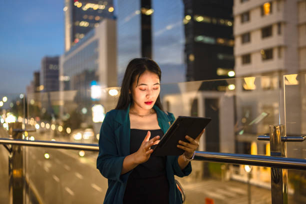 istock Young lady using digital tablet in balcony against city background 2148726299