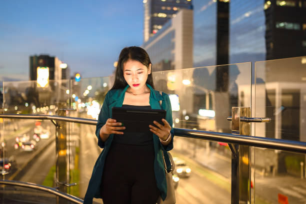 istock Young lady using digital tablet in balcony against city background 2148726305