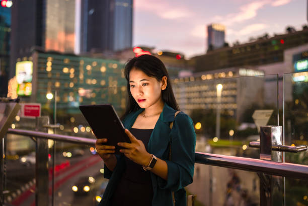 istock Young lady using digital tablet in balcony against city background 2148726393
