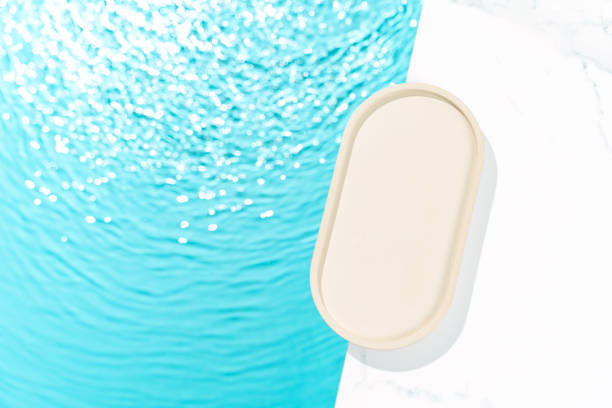 istock Minimalist cosmetics product presentation mockup scene featuring an oval tray adorned with blue water, creating a sleek and elegant visual appeal. Perfect for showcasing beauty products. 2148726774
