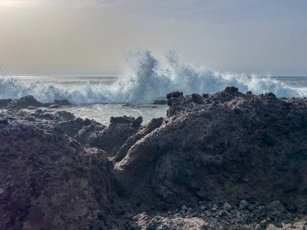 istock Rocky beach with Atlantic Ocean waves meeting with sharp underwater rocks. Sea waves crash on rocks with foam, south of Tenerife, Canary Islands 2148727569