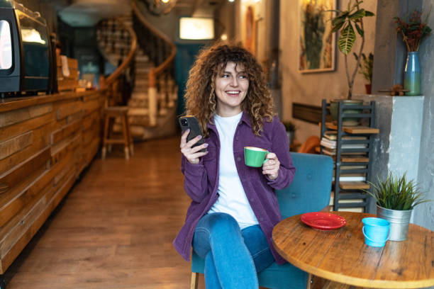 istock Caucasian woman using cell phone at coffee shop 2148727820