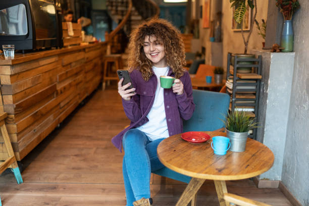 istock Caucasian woman using cell phone at coffee shop 2148727963