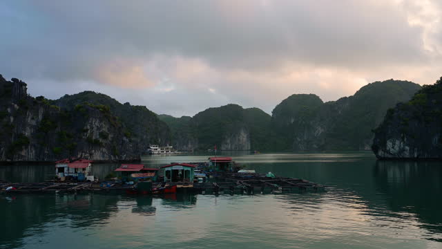 floating fishermen houses in halong bay at sunrise