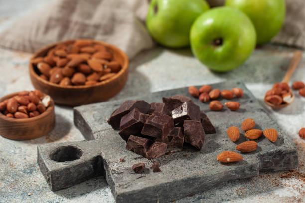istock Cubes of dark artisan chocolate. Dark chocolate chunks with almonds and fresh apples 2148730155