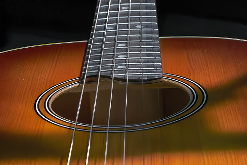 Image of a resonant hole in the soundboard of a guitar neck with strings