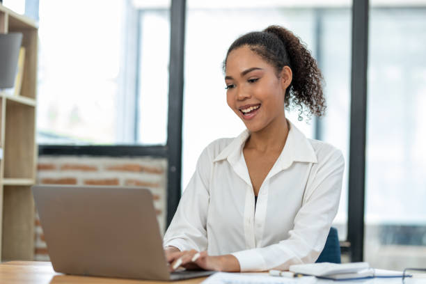 istock Focused young businesswoman analyzing financial reports at a modern workspace with a laptop and office supplies. 2148730565