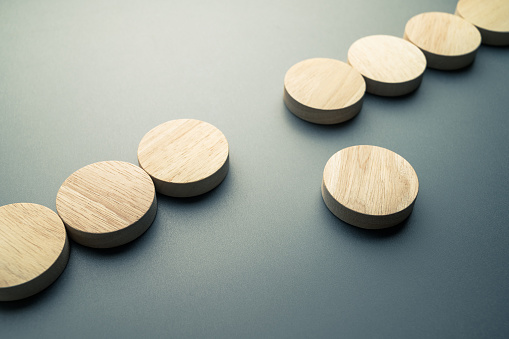 Concept image of a round wood block that move out from its position of a row, different, and original concept, create own way, or solution to solve the gap problem