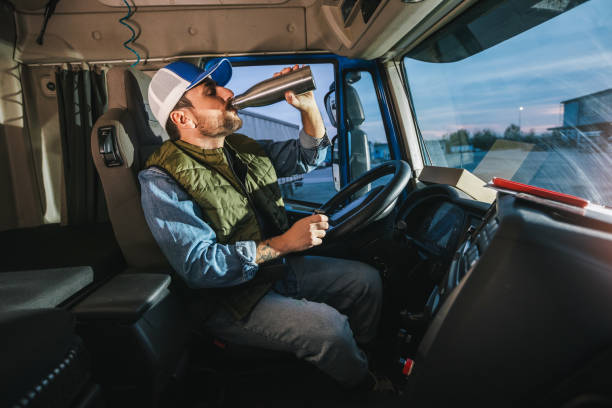istock Young handsome man driving long vehicle and drinking coffee so he could get some energy. 2148732582