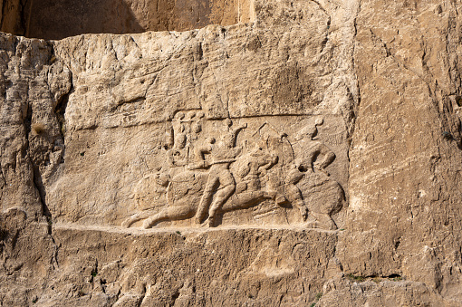 Detailed stone carvings depicting historical figures and events at Naqsh-e Rostam, a testament to the grandeur of ancient Persian architecture, Iran.