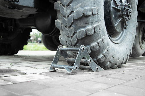 Close up details of the  truck tyre  with a parking chock