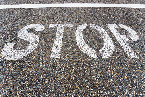 STOP sign on the road with textured asphalt. Top view