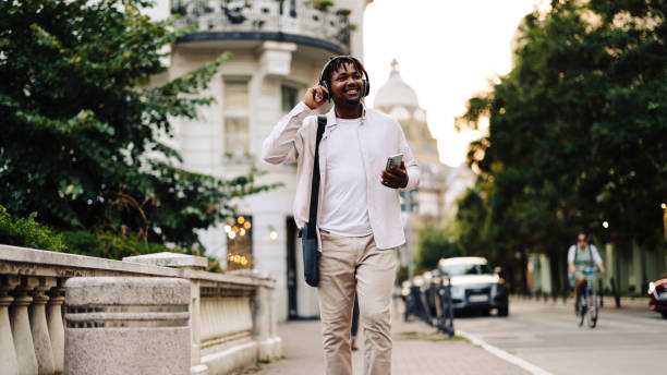 istock Young smiling man  laughing, singing and streaming audio or radio on wireless headset 2148734442