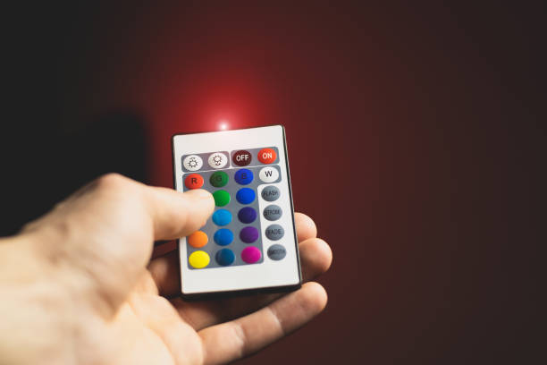 istock Man is adjusting Atmosphere Neon Light with Remote Control and turn on red colour. Colorful RGB Bulb. LED Multicolor Lump. Household Lighting. Blogging and business modern cool lighting. 2148734846
