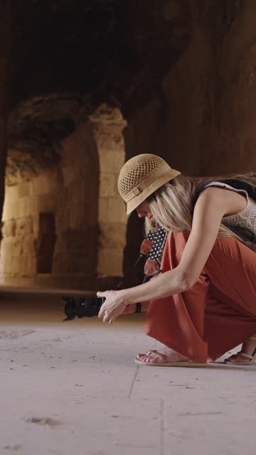Blonde tourist woman taking a photo in Ancient Jerash ruins, Jordan