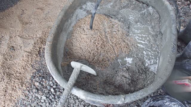 Worker Mixing Cement in a Basin, Construction and Manual Labor concept.
