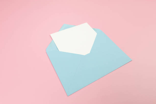 istock Top view of light blue envelope, white card on pink background. 2148735517