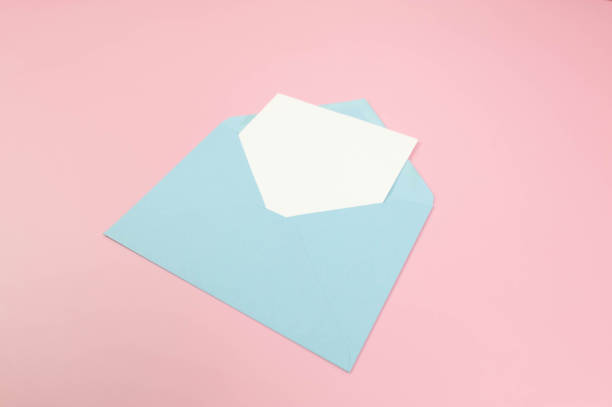 istock Top view of light blue envelope, white card on pink background. 2148735525