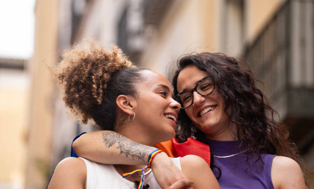Headshot of two multiethnic lesbian women in love hugging and smiling enjoying time together Headshot of two multiethnic lesbian women in love hugging and smiling enjoying time together. lesbian couple embracing stock pictures, royalty-free photos & images