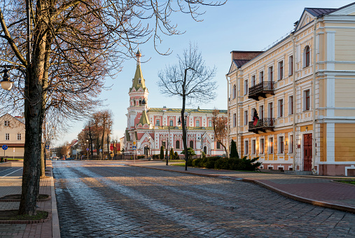 View of the old street in the city center with the name of the writer Eliza Olezhko - Olezhko Street and the Holy Intercession Cathedral on a sunny day, Grodno, Belarus