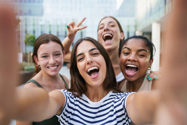 happy girls taking a selfie photo for social media - group of women students smiling at university - tiener fotos stockfoto's en -beelden