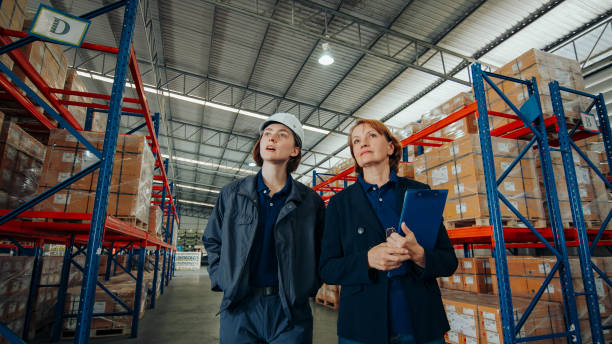 istock Logistics professionals converse while walking through the aisles of a storage facility, focused on improving operational processes. 2148737418