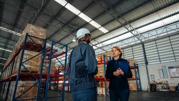 istock Logistics professionals converse while walking through the aisles of a storage facility, focused on improving operational processes. 2148737452