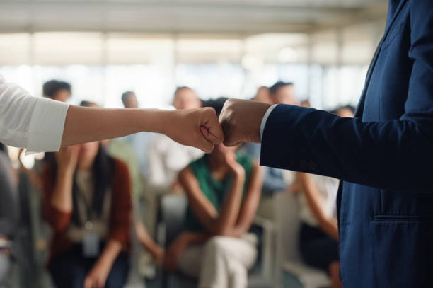 Workshop, employees and fists for collaboration or teamwork for corporate partnership in business. People, professional and together in seminar or conference with staff in company for solidarity