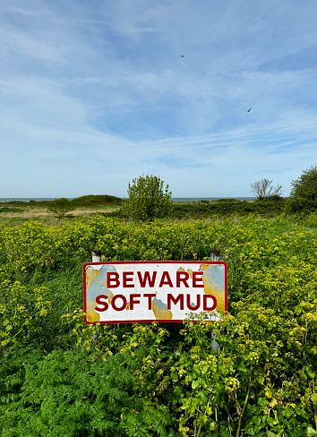 A sign warning of soft mud, next to a cycle route in Herne Bay, Kent